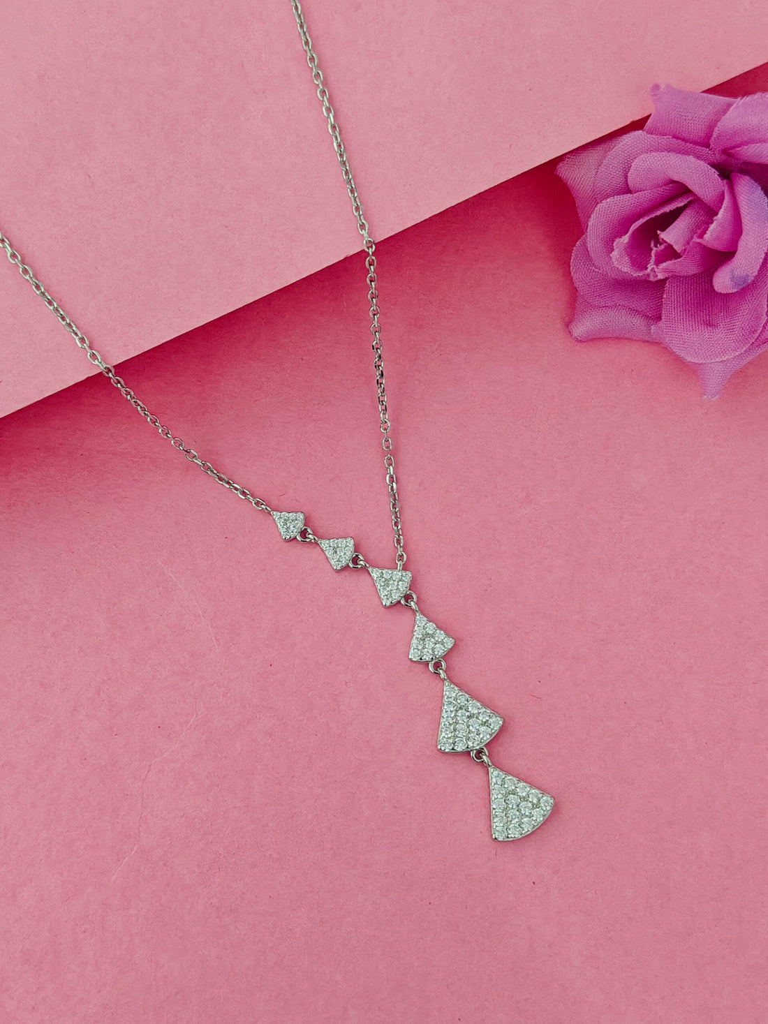 Necklace with heart-shaped pendants on a pink background