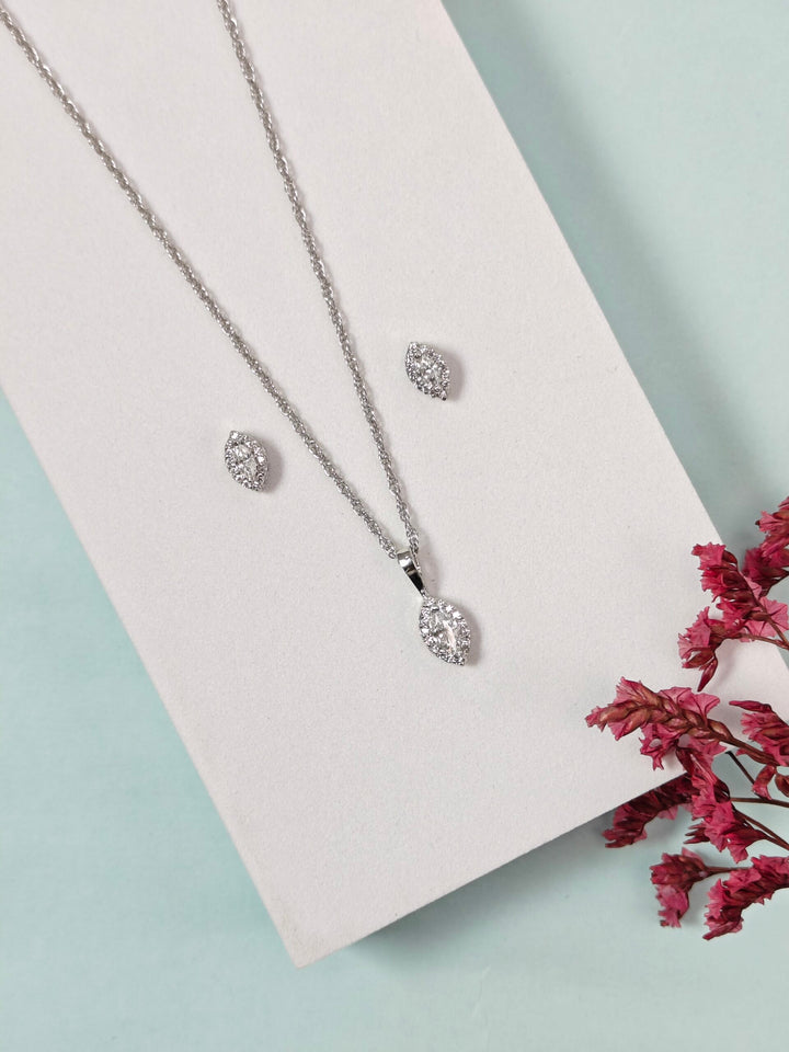 Silver jewelry set with necklace and earrings on a light pink card with pink flowers.