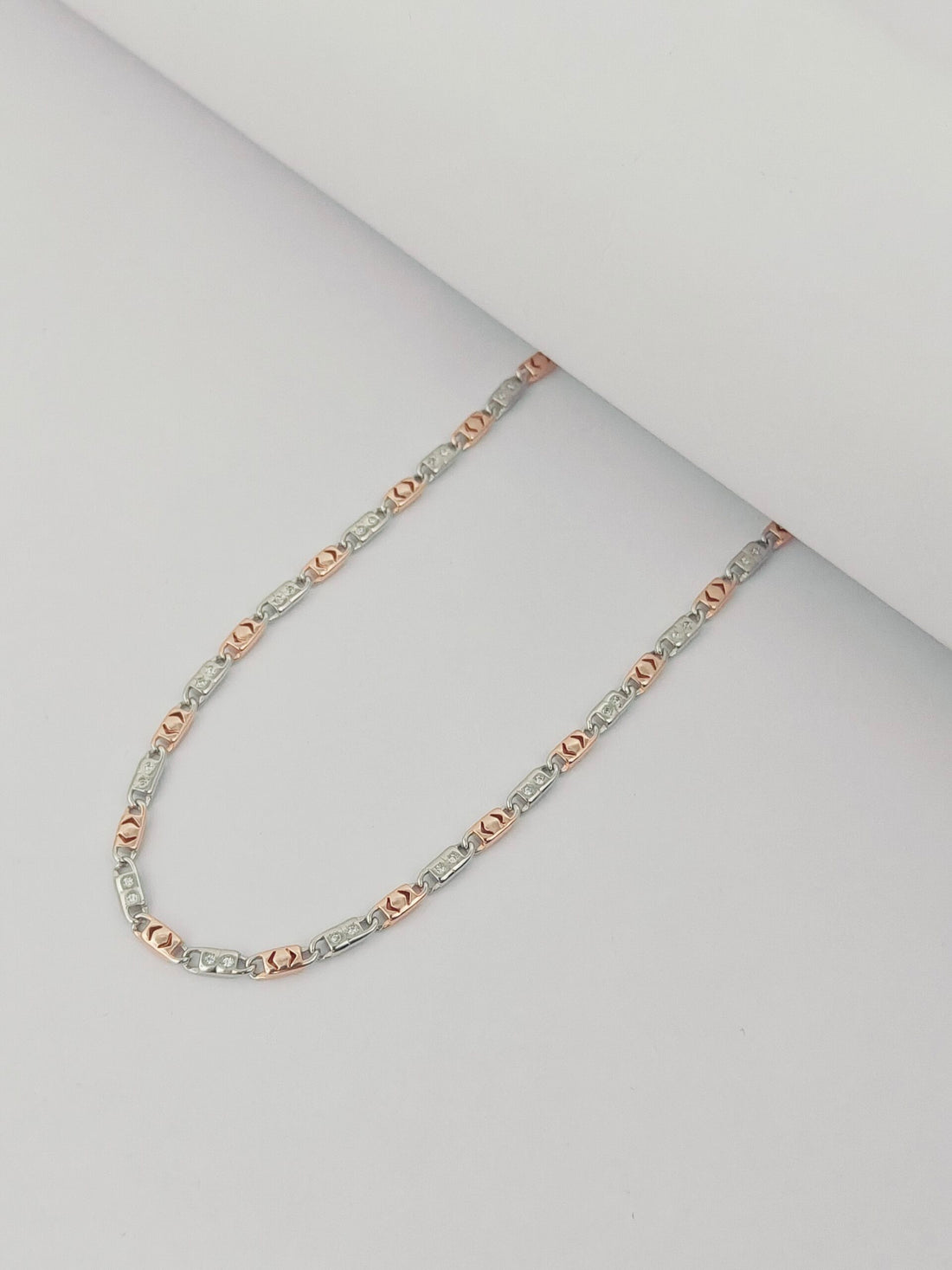 Necklace with rose gold and silver beads on a light gray background