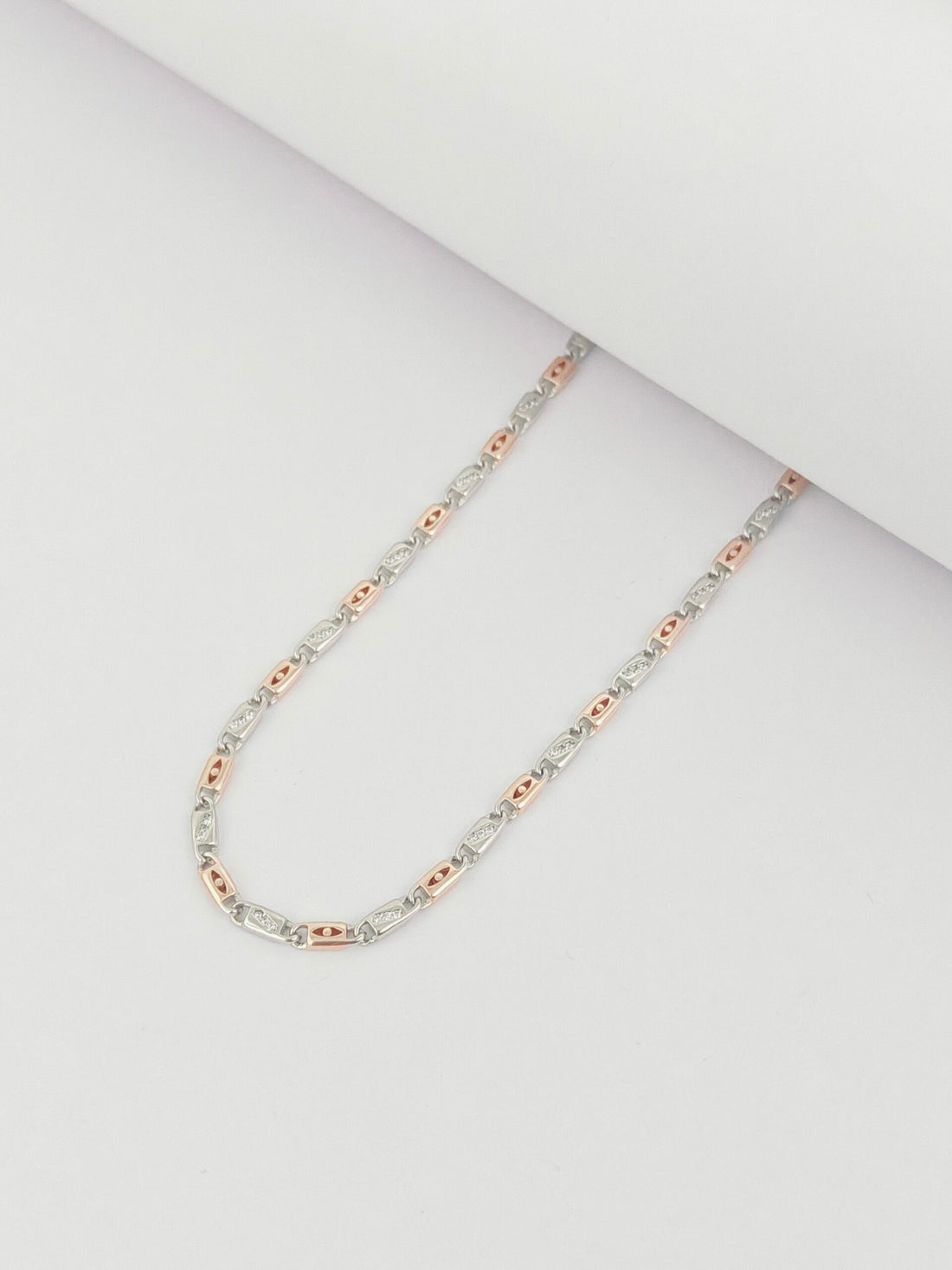 Two-tone chain necklace on a light gray background