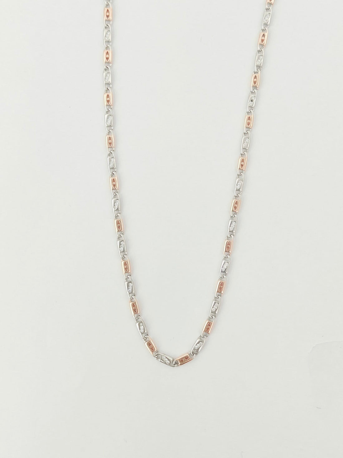 Silver chain necklace on a light gray background