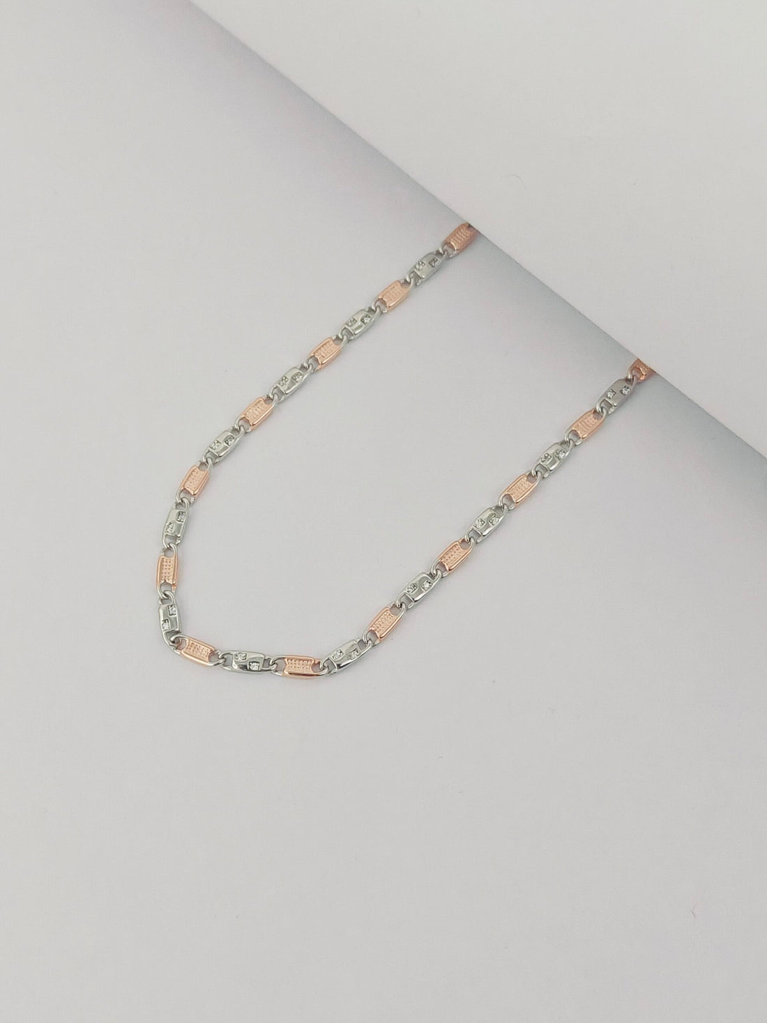 Two-tone chain necklace on a light gray background
