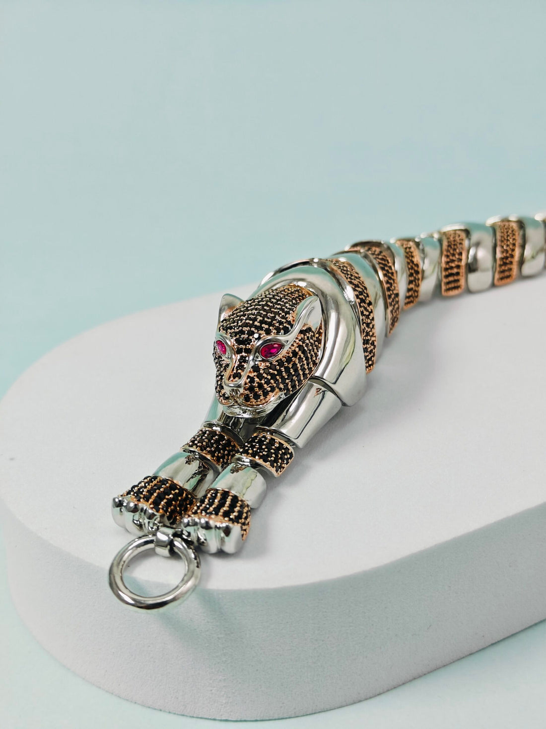 Silver panther keychain with gemstone eyes on a light blue background