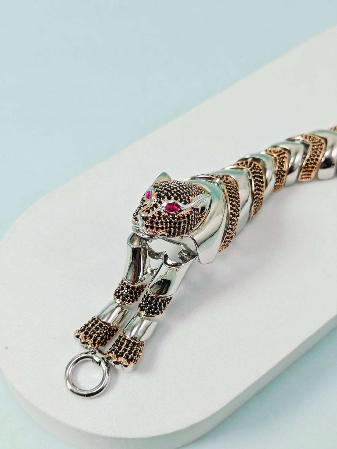 Silver bracelet with a panther design on a white surface