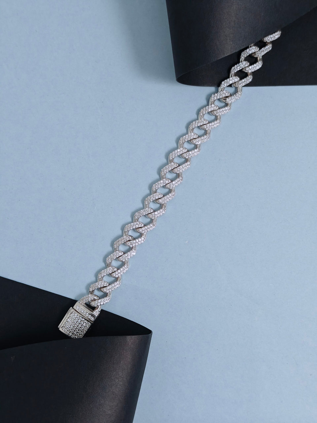 Silver chain bracelet on a light blue background