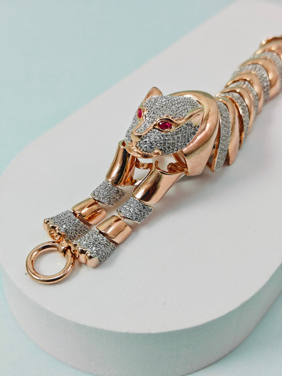 Luxury rose gold and diamond-encrusted keychain on a light blue background