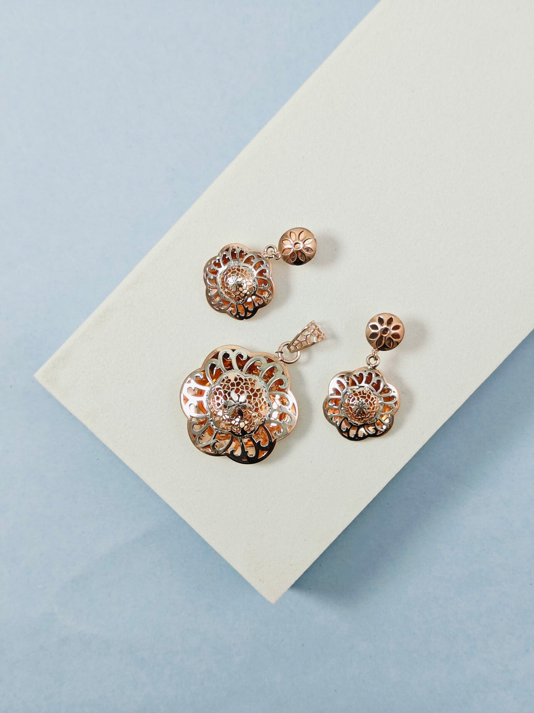 Set of floral earrings on a light blue background