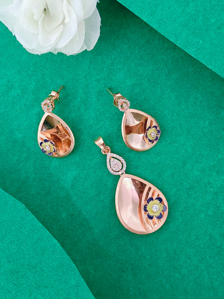 Teardrop-shaped earrings with floral designs on a green background