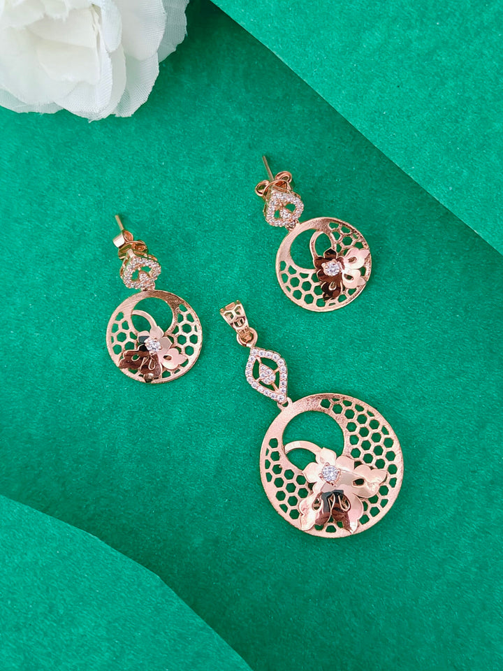 Rose gold earrings on a green background