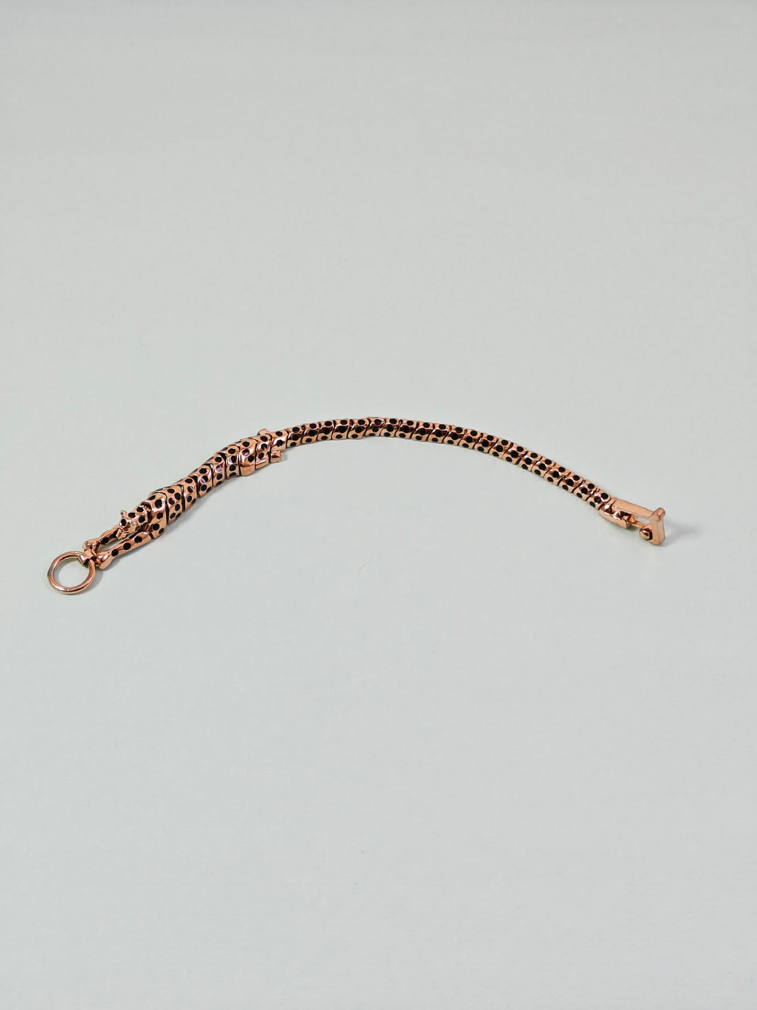 Rose gold chain bracelet on a light gray background