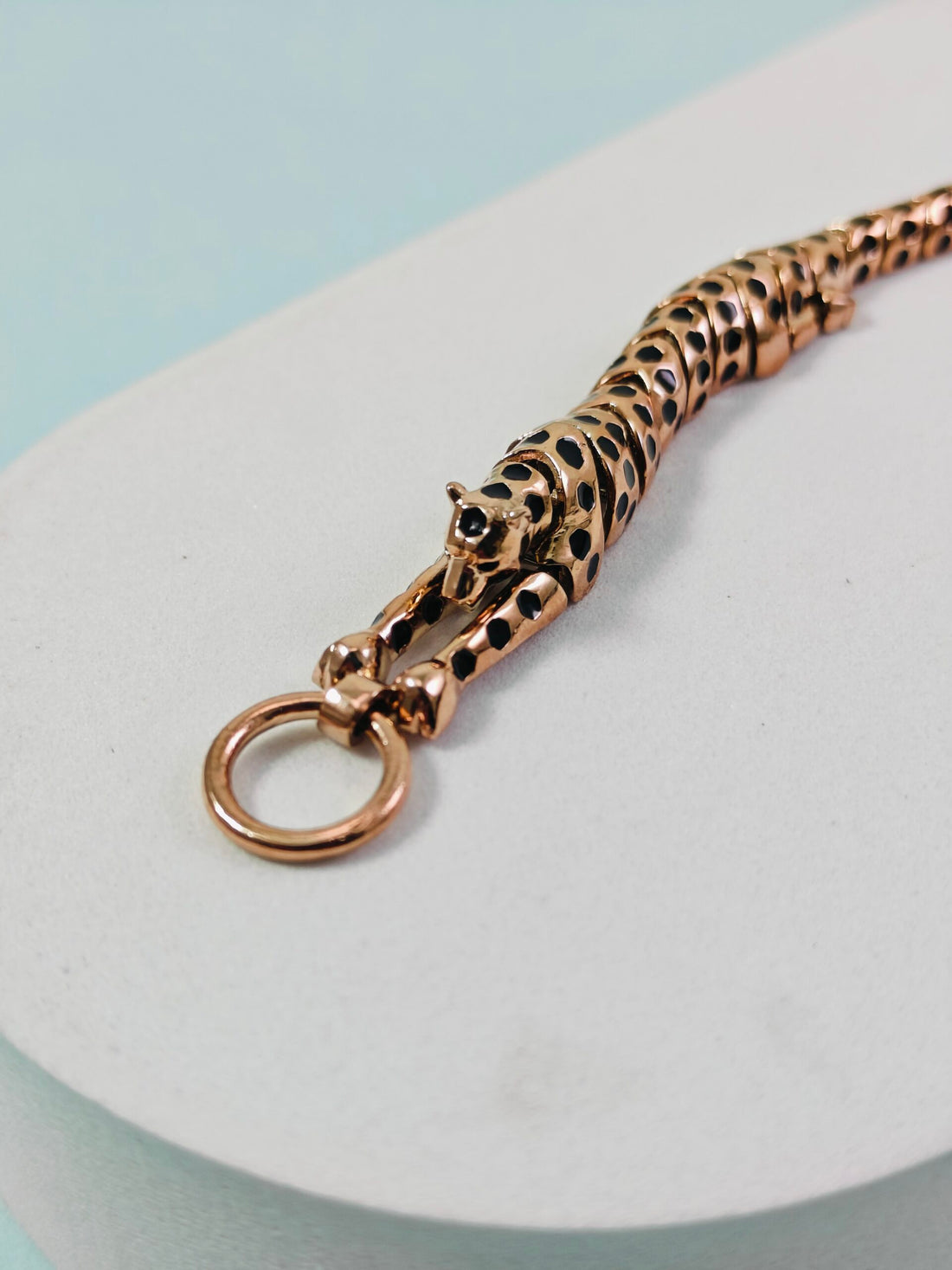 Rose gold keychain with leopard design on a light blue background