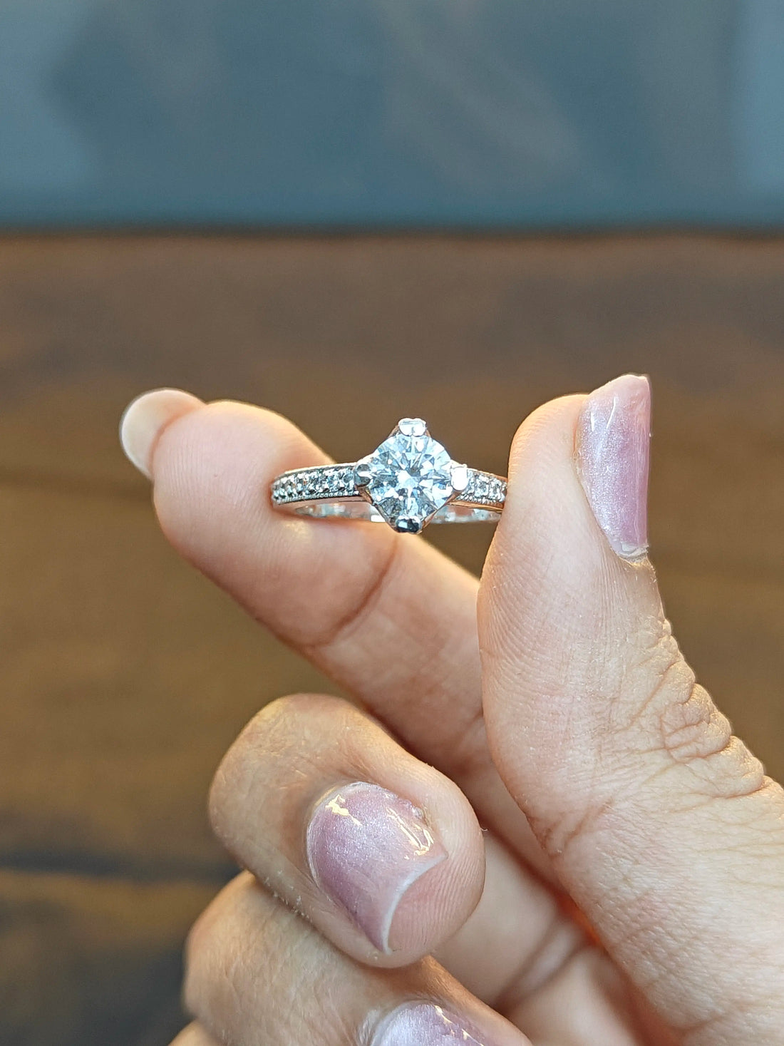 Diamond ring on a finger with a blurred background