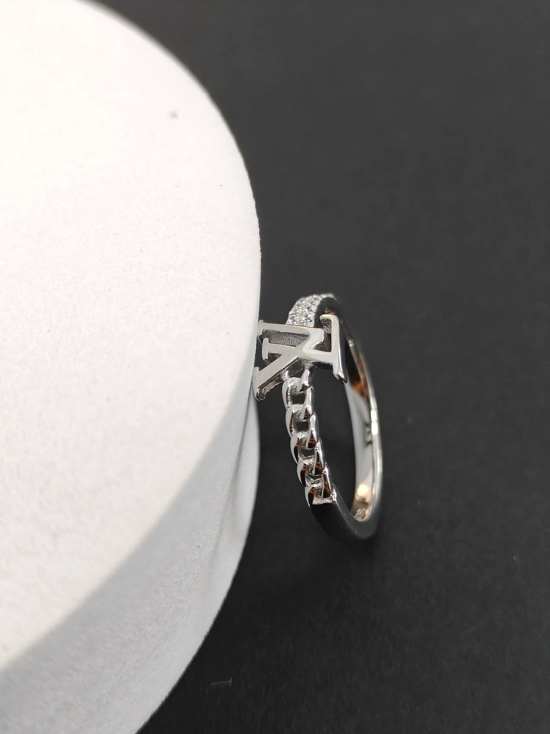 Silver ring with chain detail on a black and white background