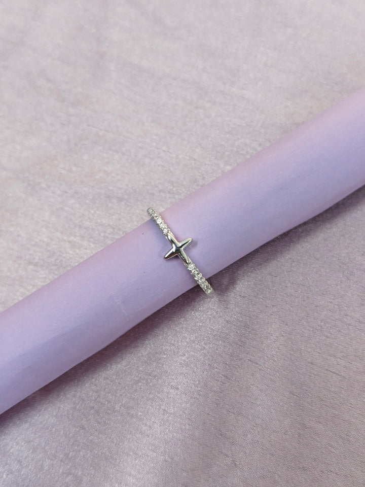 Silver ring with a star design on a pink surface