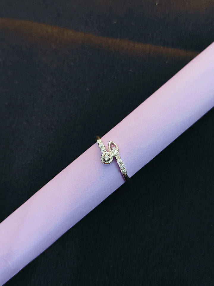 Gold ring with small diamonds on a purple cylindrical object against a black background