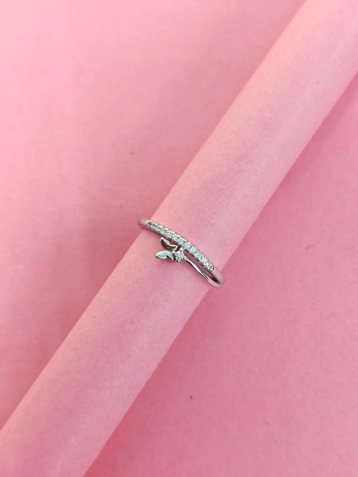 Silver ring with small diamonds on a pink background