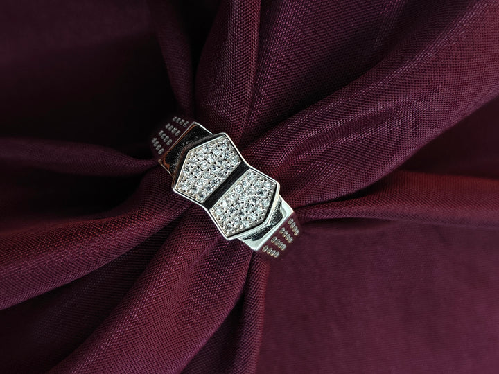 Silver ring with gemstones on a burgundy fabric background