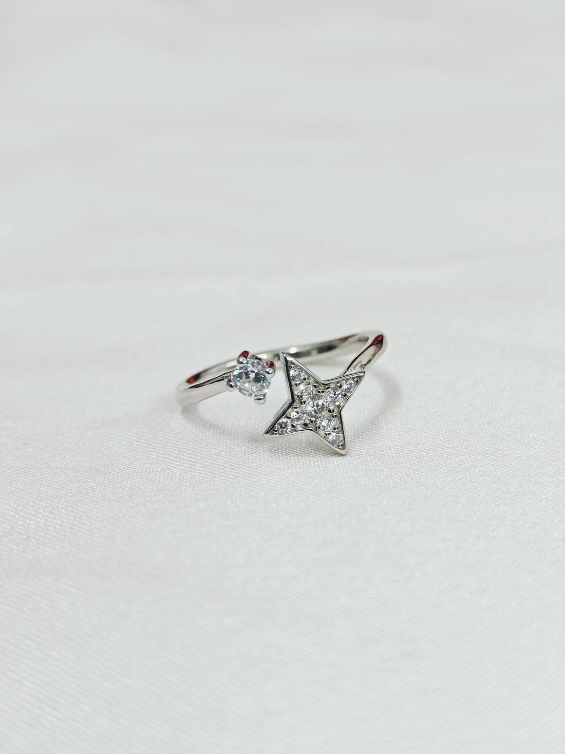 Silver ring with star design on a light gray background
