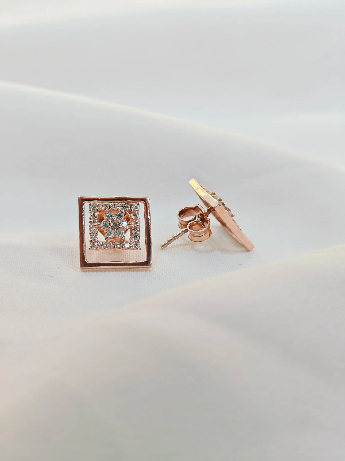 Rose gold square-shaped earring on a light gray background