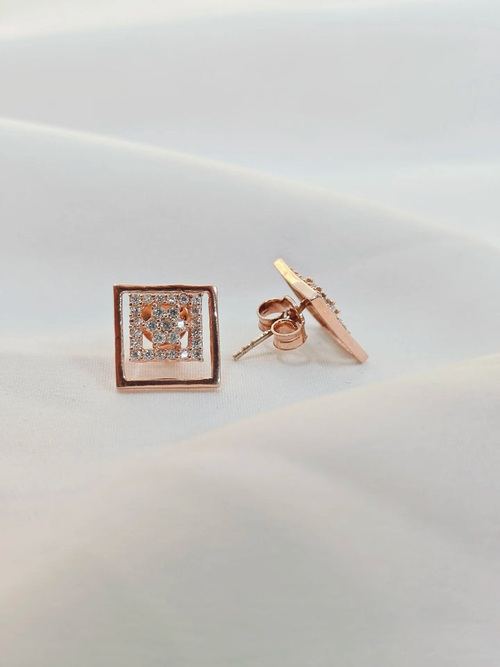 Rose gold square-shaped earring on a light gray background