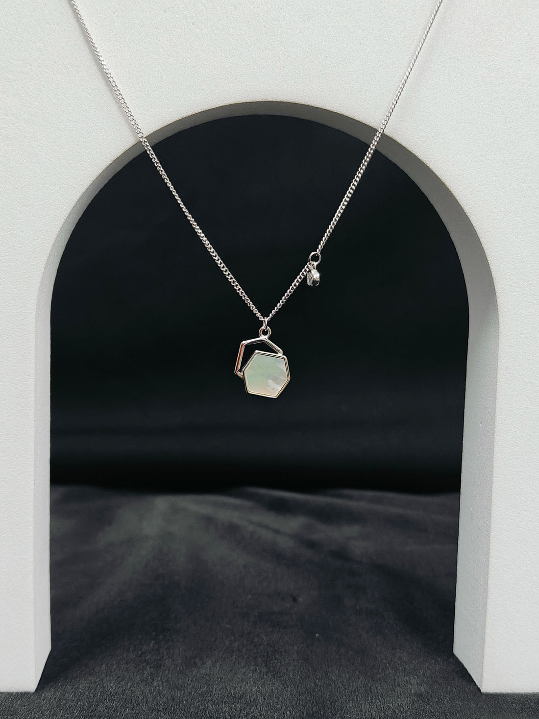 Necklace with a pendant hanging from an archway