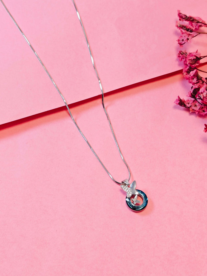 Silver necklace with a pendant on a pink background