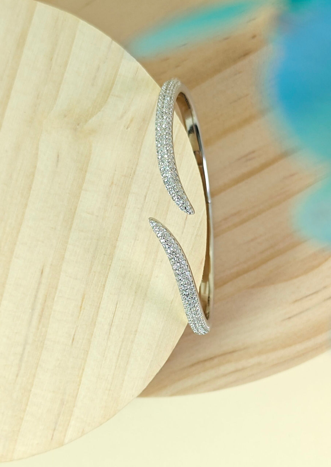 Silver hoop earrings on a light wooden surface