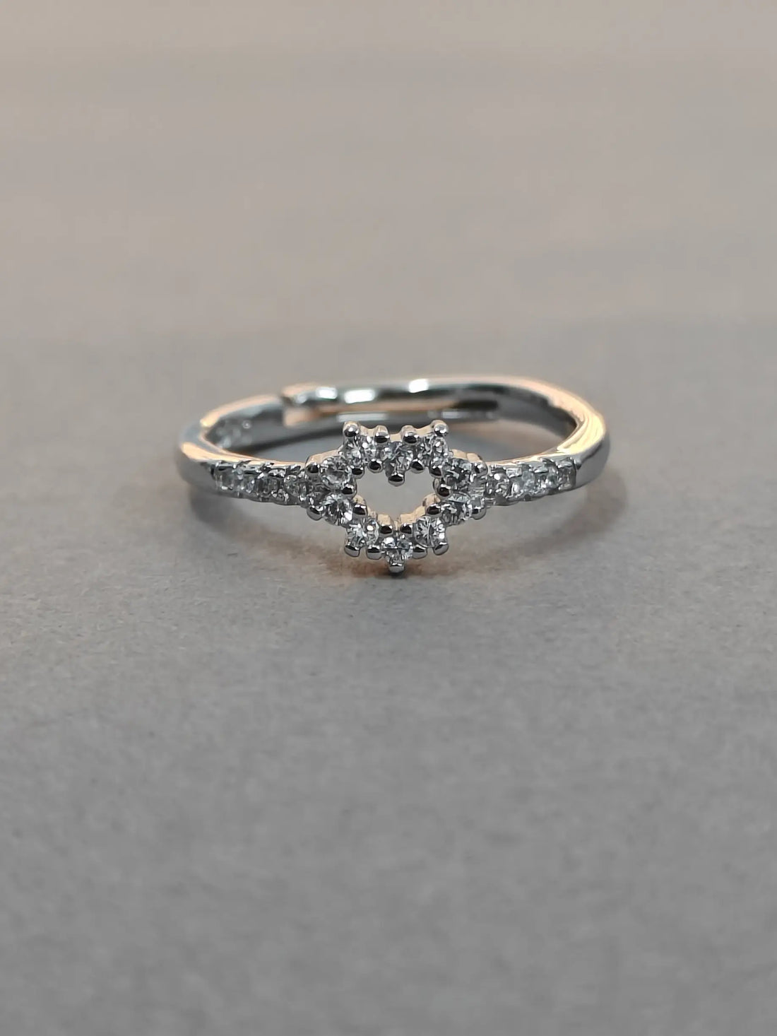 Silver ring with small diamonds on a gray background