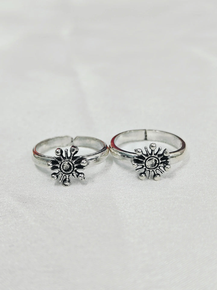 Two silver rings with sunflower designs on a light gray background