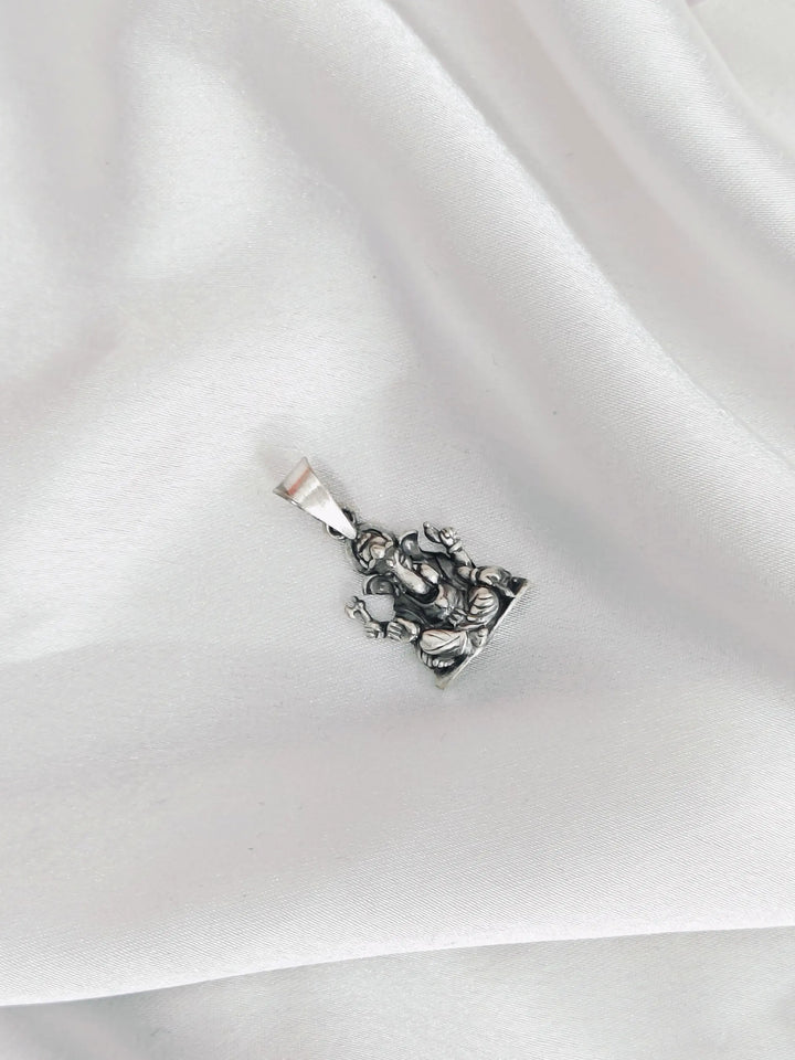 Silver pendant on a white fabric background