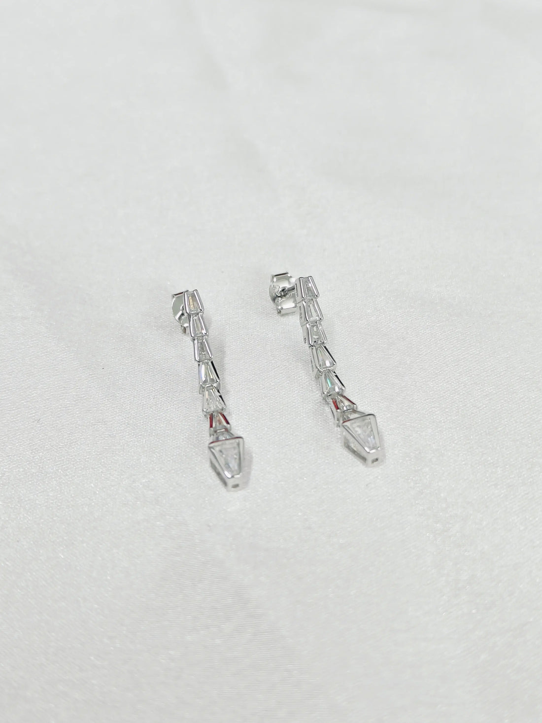 Pair of silver earrings on a light gray background