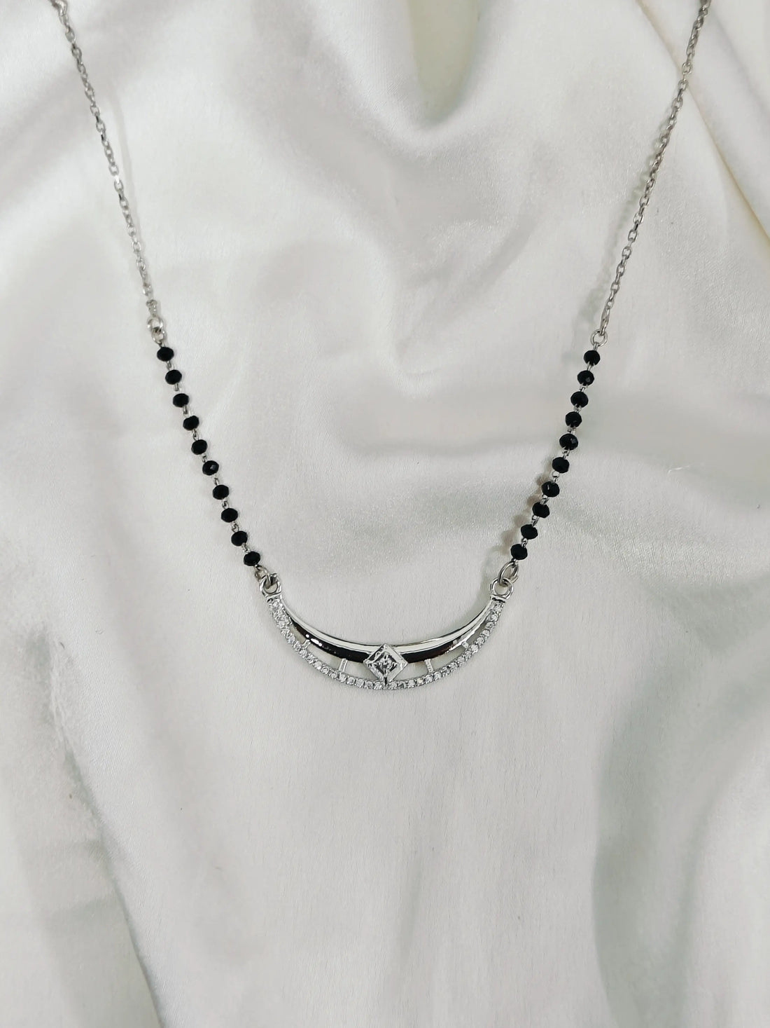 Necklace with black beads and a silver clasp on a white background