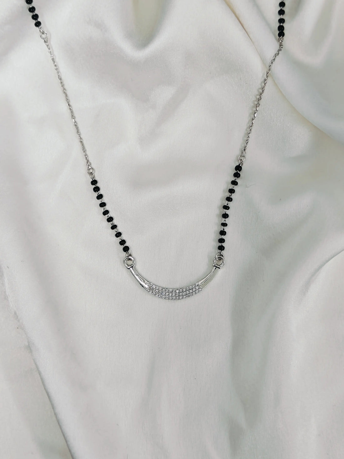 Necklace with black beads and a silver clasp on a white background