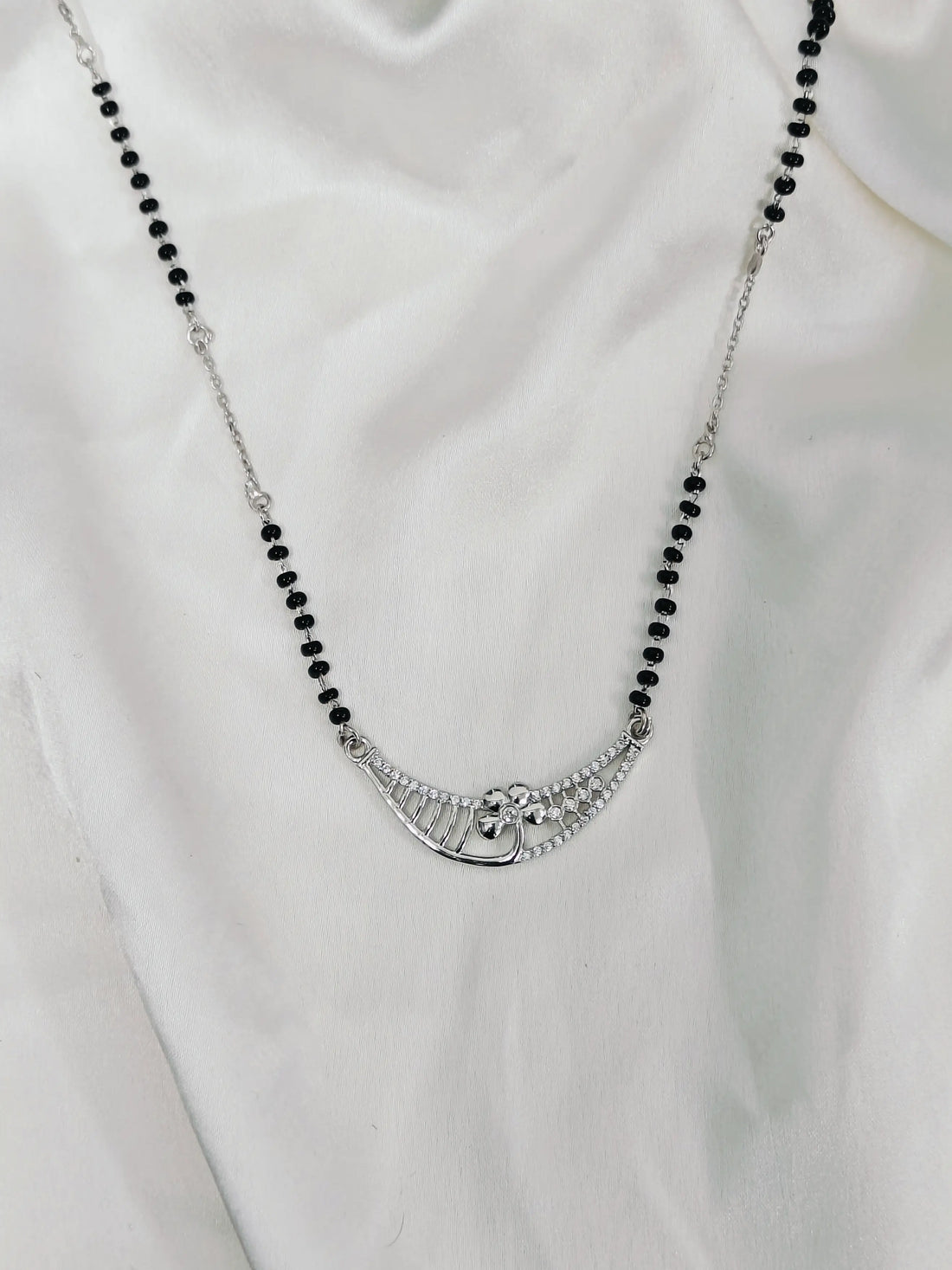 Necklace with black beads and a silver clasp on a white background