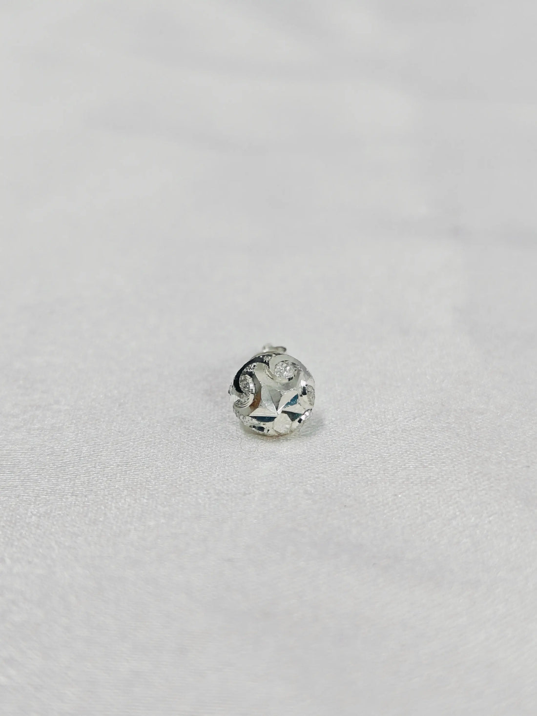 Silver ring with a diamond on a light gray background