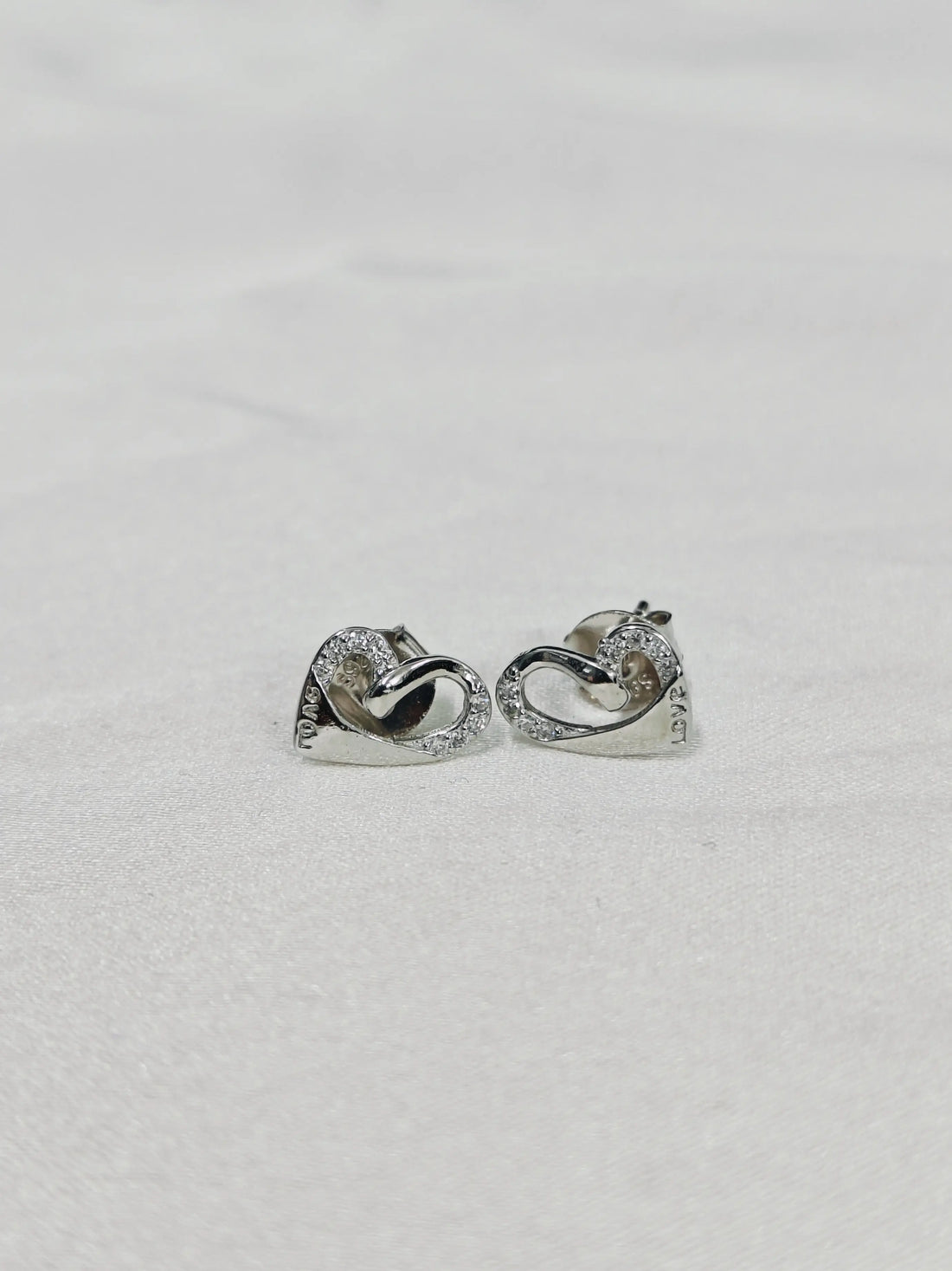 Pair of silver hoop earrings on a light gray background