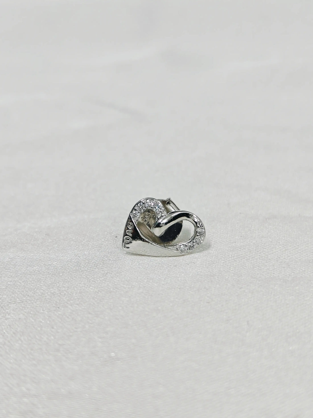 Silver ring with a diamond on a light gray background