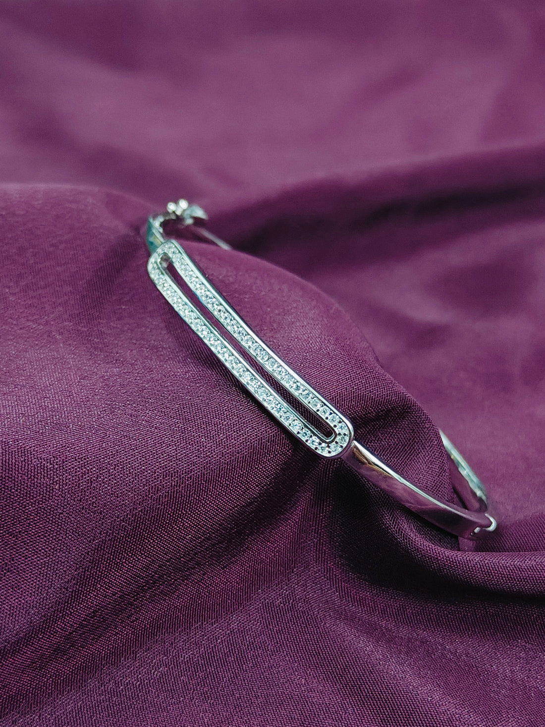 Silver brooch on a purple fabric background