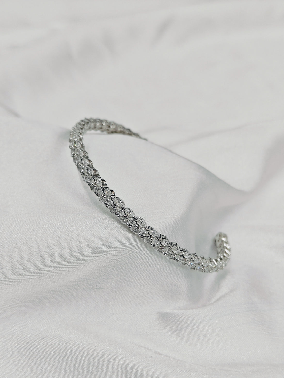 Silver bracelet on a light fabric background