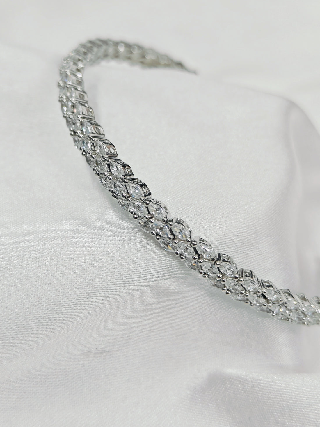 Silver headband with clear gemstones on a white background