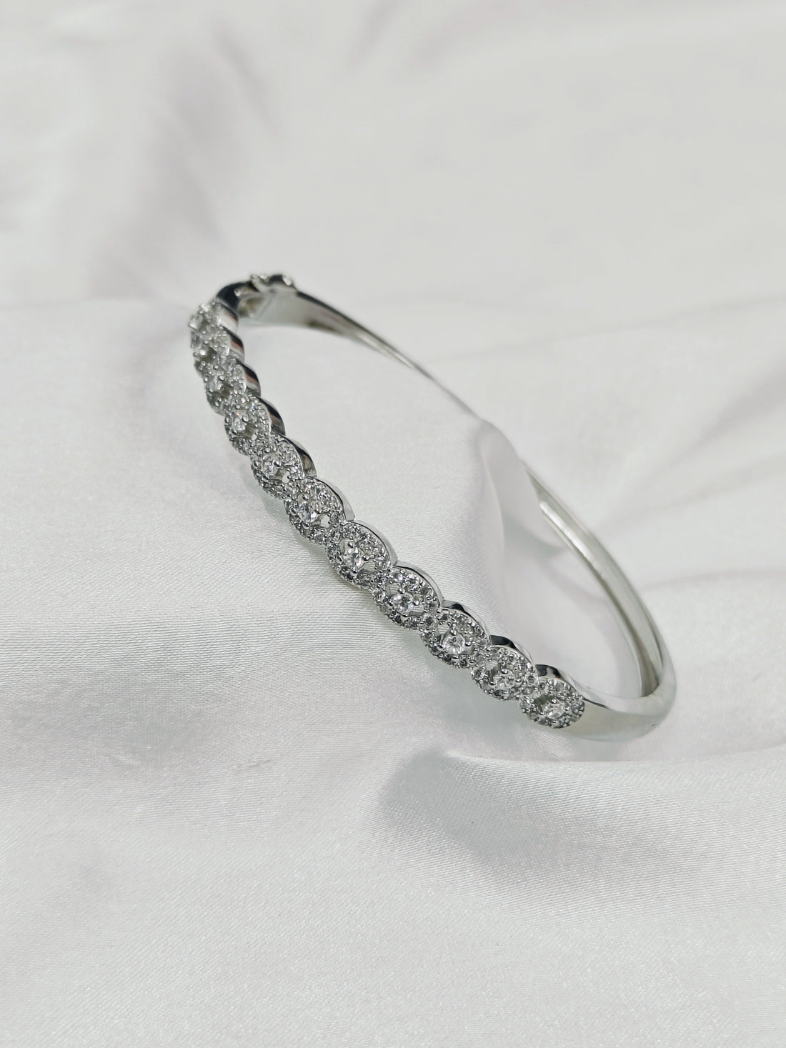 Silver bracelet with clear stones on a white background