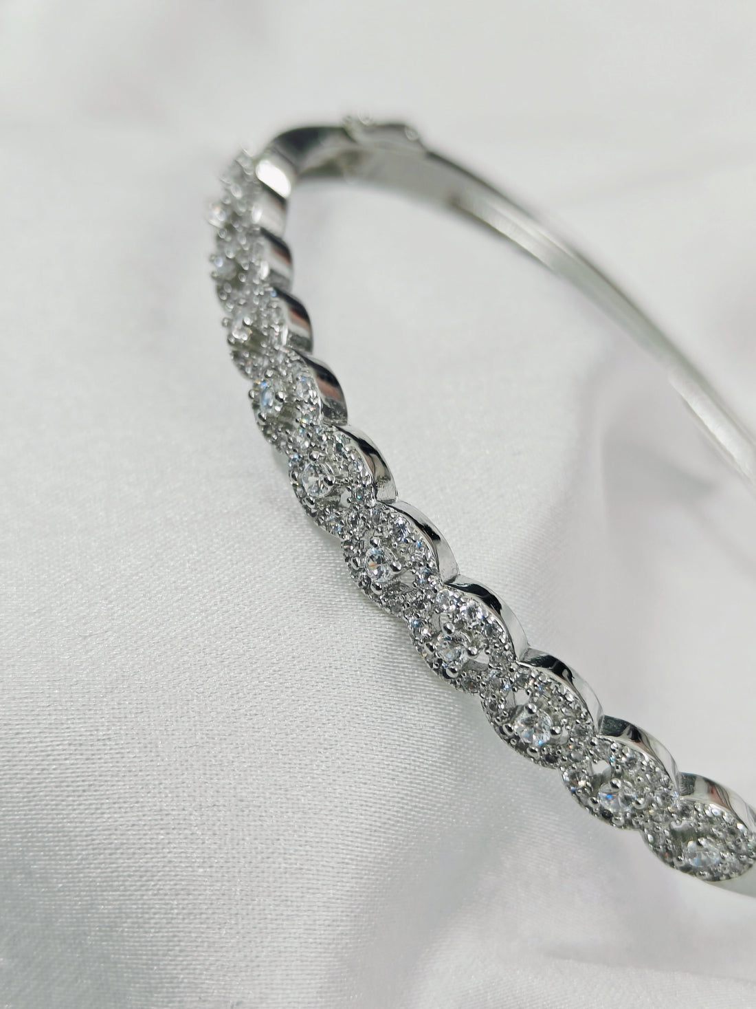 Silver bracelet with clear stones on a white background