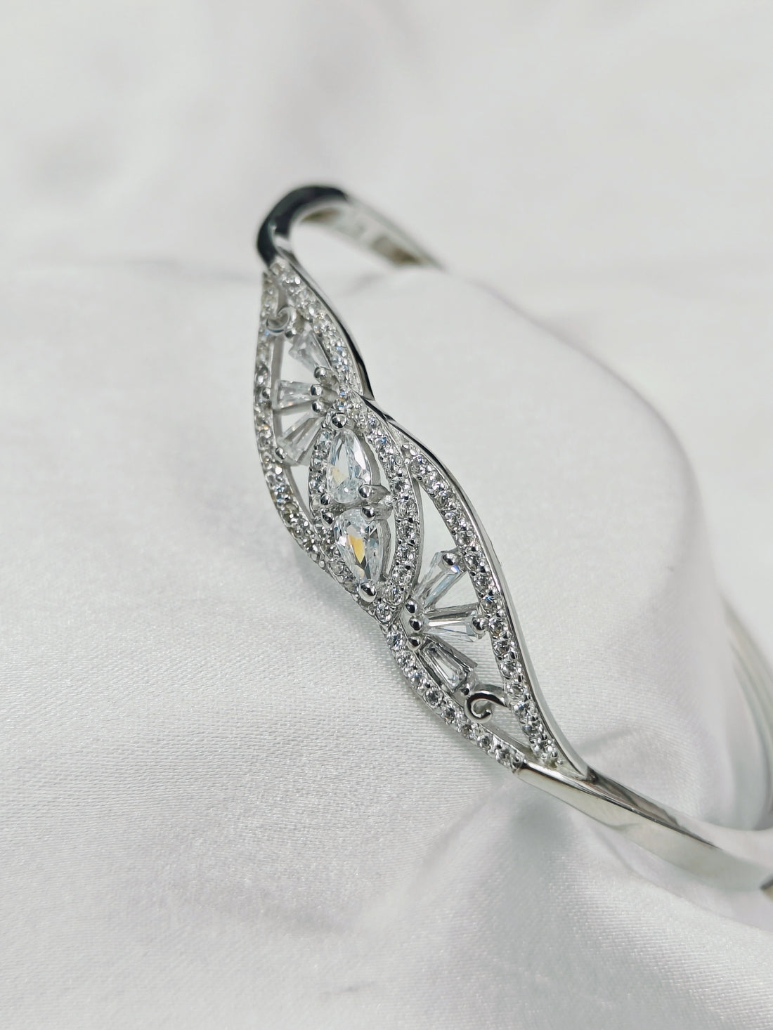 Silver bracelet with diamond accents on a white background