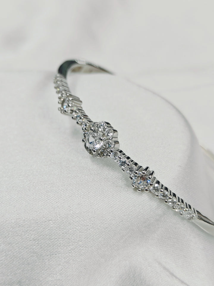 Silver bracelet with clear gemstones on a light gray background
