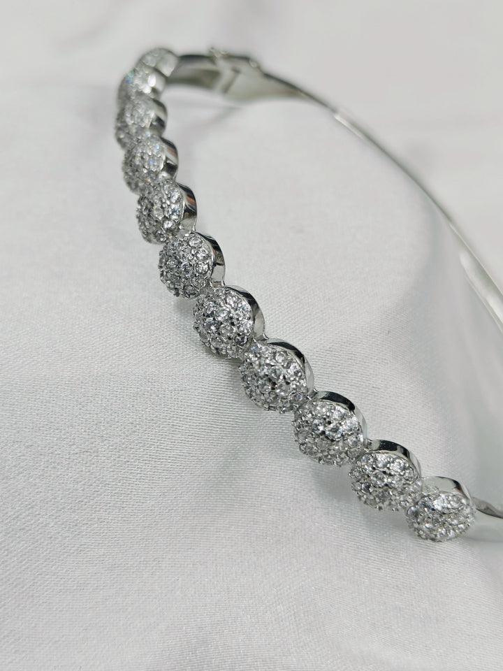Silver bracelet with clear stones on a light gray background