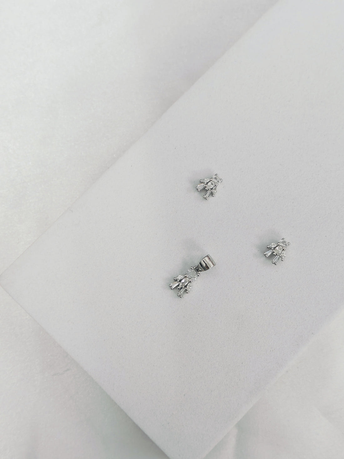 Pair of silver earrings on a light gray background