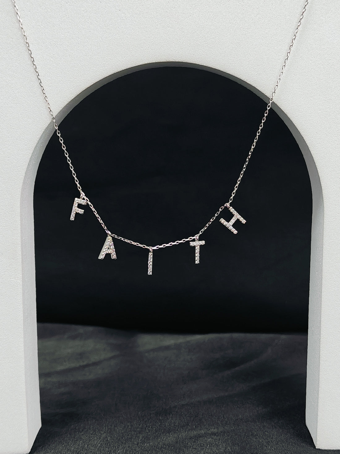 Necklace with 'FAITH' pendant on a dark background