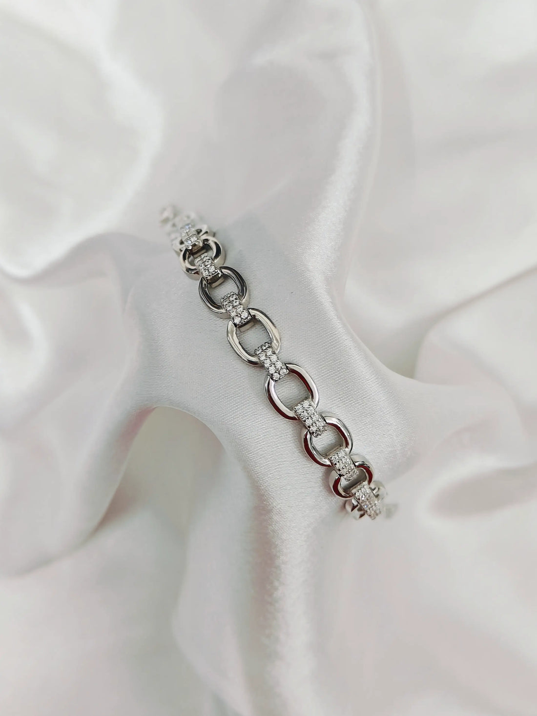 Silver bracelet with clear beads on a white fabric background