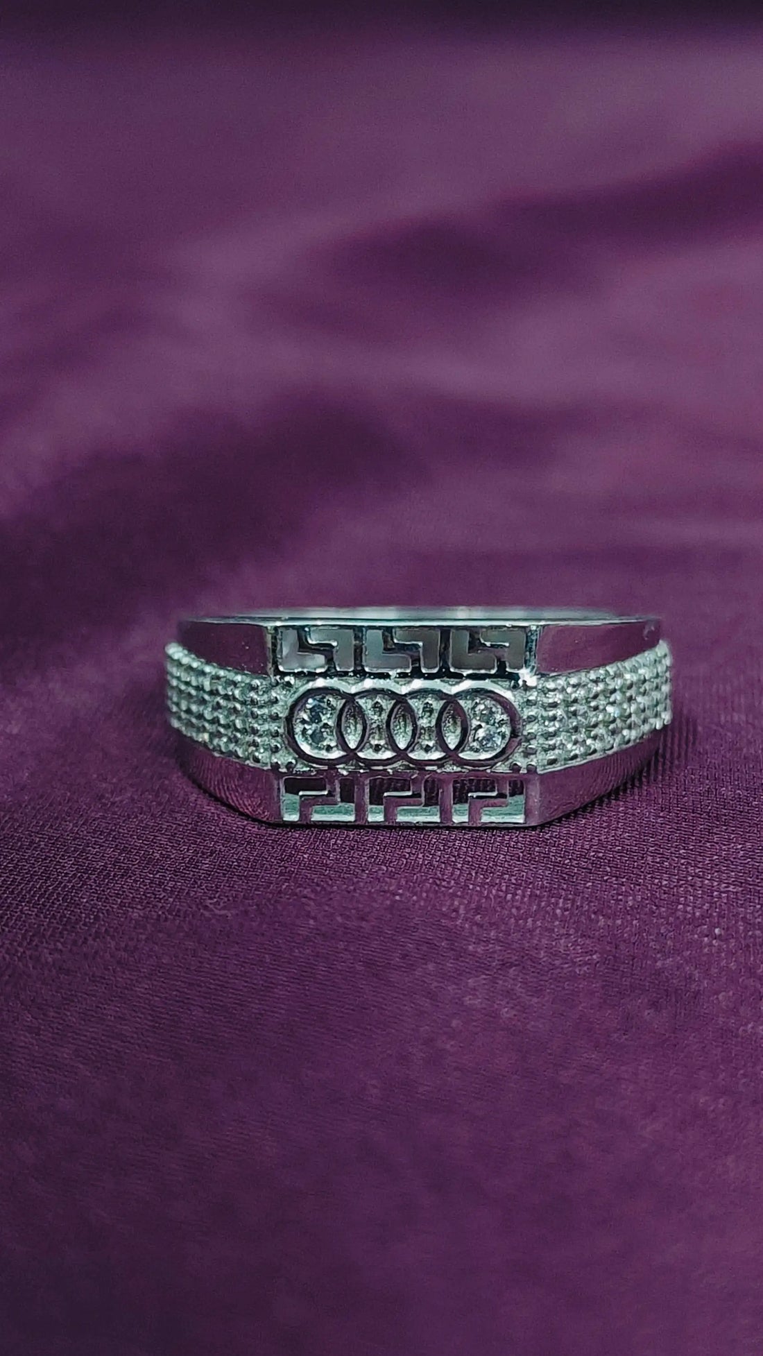 Silver Audi ring on a purple fabric background