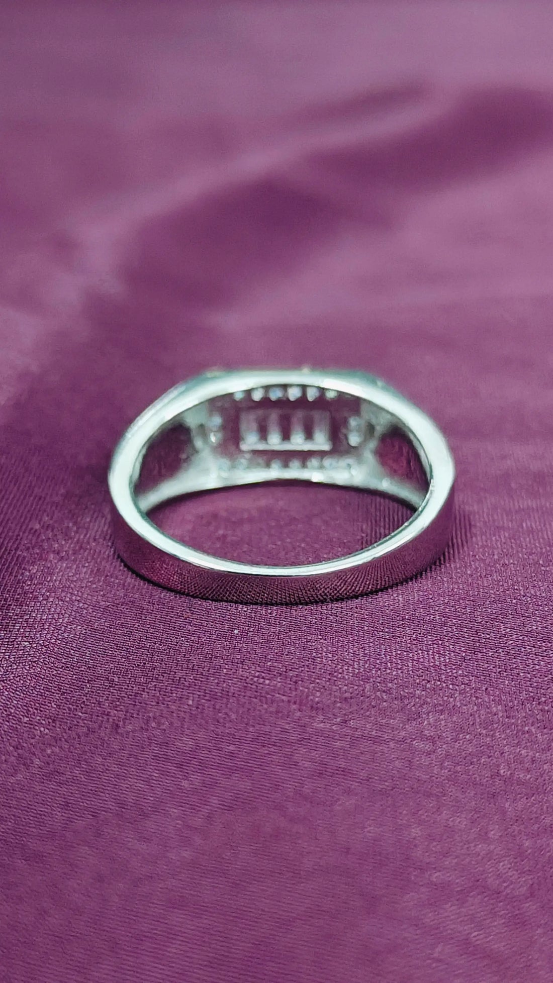 Silver ring on a purple fabric background